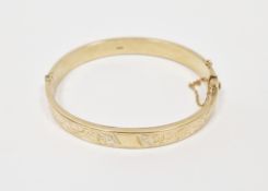 9ct gold flattened bangle with engraved decoration, 10.3g  Condition Report Some surface wear and