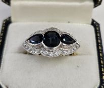18ct gold, sapphire and diamond dress ring, the central oval sapphire 8mm x 5mm approx. flanked by