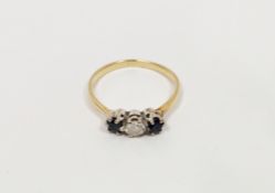 Gold-coloured metal, sapphire and diamond ring set single diamond flanked by two sapphires, all claw