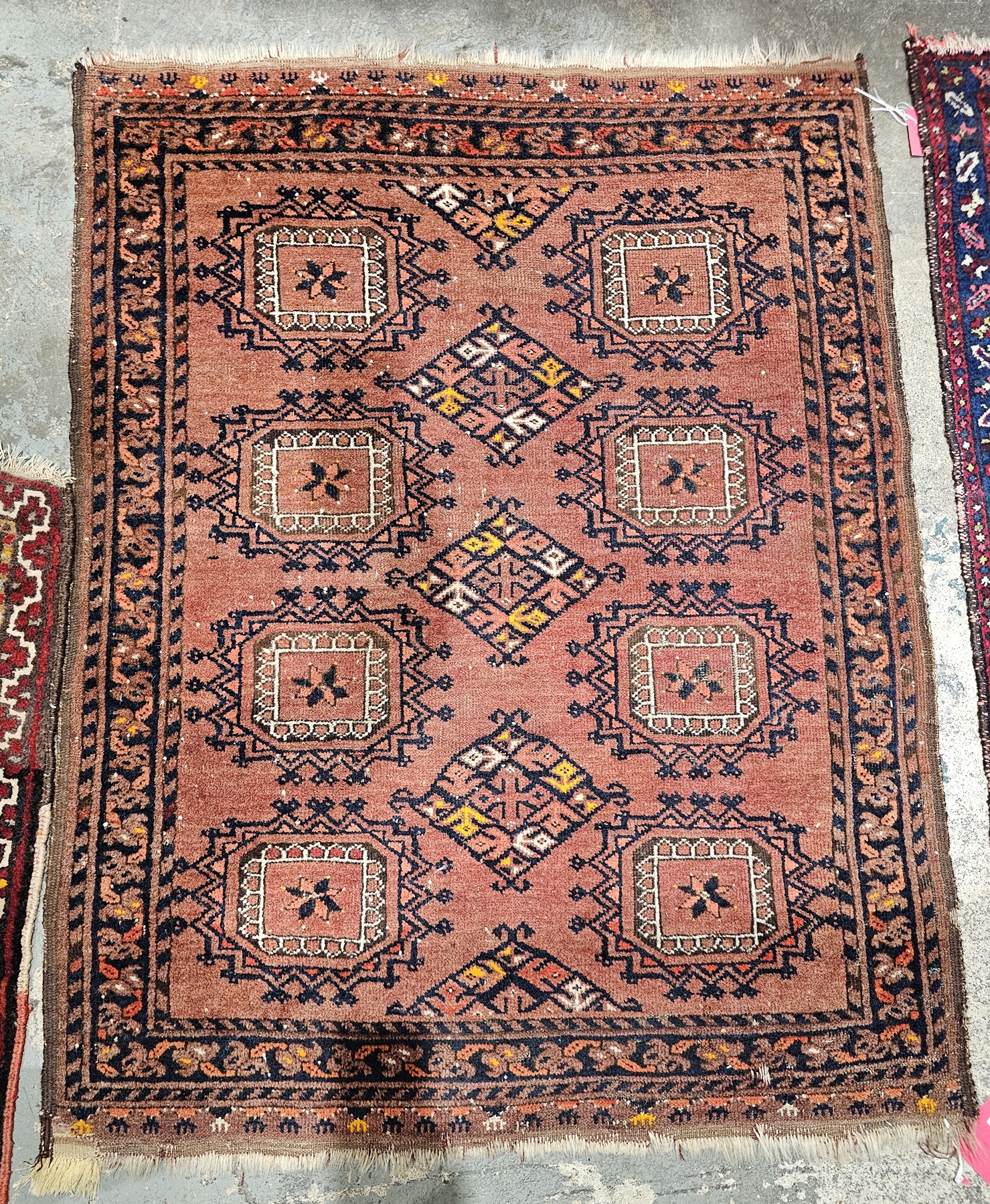 Eastern red ground rug with three central lozenge medallions flanked by two rows of four elephant