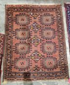 Eastern red ground rug with three central lozenge medallions flanked by two rows of four elephant