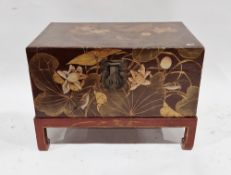 Chinese style painted chest on stand, decorated with birds within foliage on a burgundy ground, with