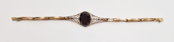 9ct gold and garnet bracelet set oval cut stone with scroll shoulders, having small set garnets (