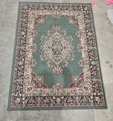 Modern Persian style green ground rug with central floral medallion, floral spandrels and multiple