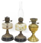 Three Victorian oil lamps, one with mottled glass reservoir, another with faceted clear glass