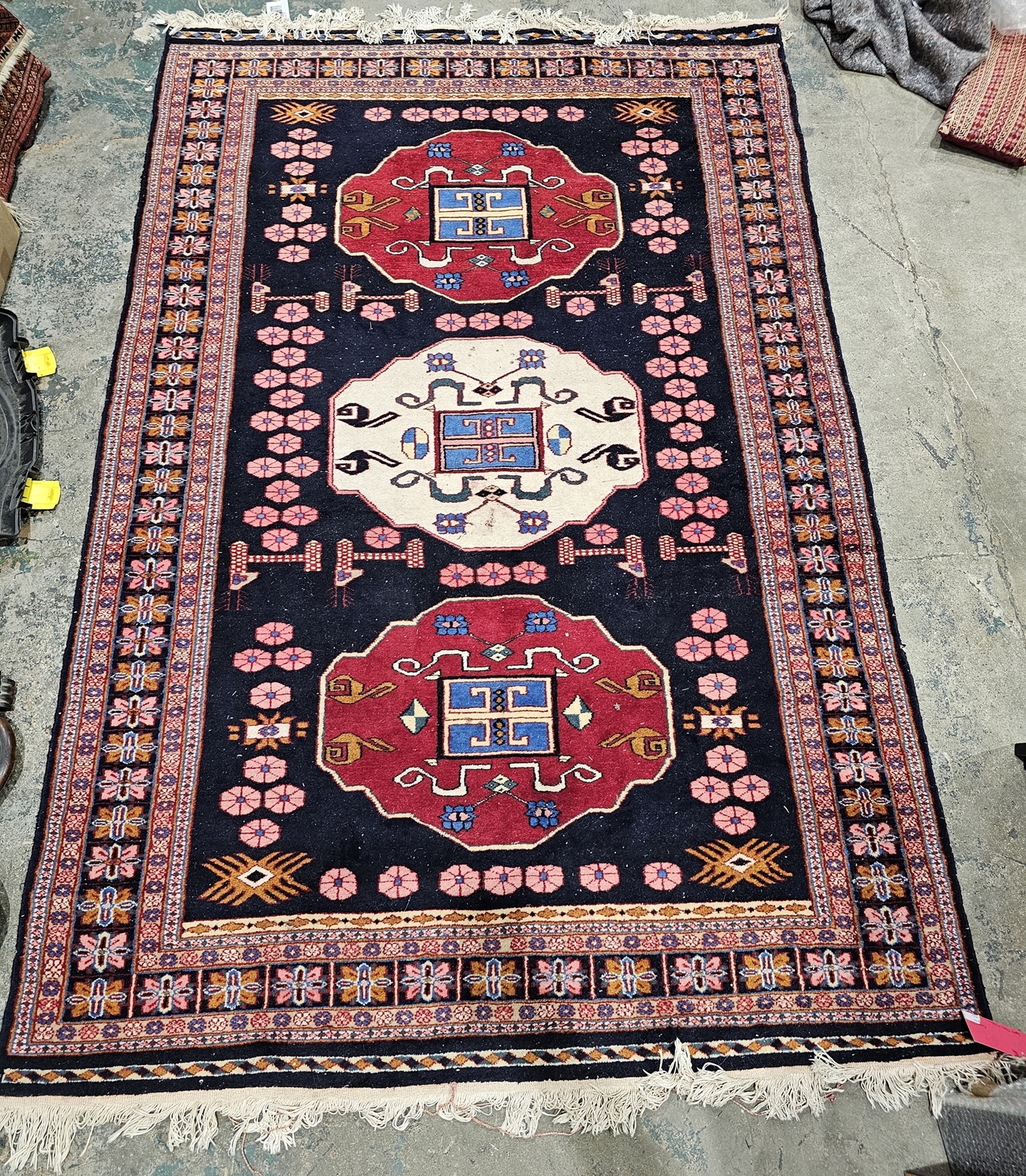 Large eastern midnight blue ground rug with three central geometric medallions, multiple geometric