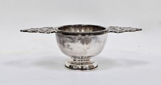 Silver tea strainer, London 1995, Wakely & Wheeler, with ornate pierced twin handles and plain