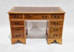 Yew wood twin-pedestal desk, the brown leather inset top with thumb moulded edge over an arrangement