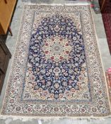 Large Persian midnight blue ground rug with central cream floral medallion on floral field, floral