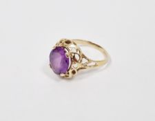 14K gold and purple stone ring, the oval stone in scroll bordered mount (size P)