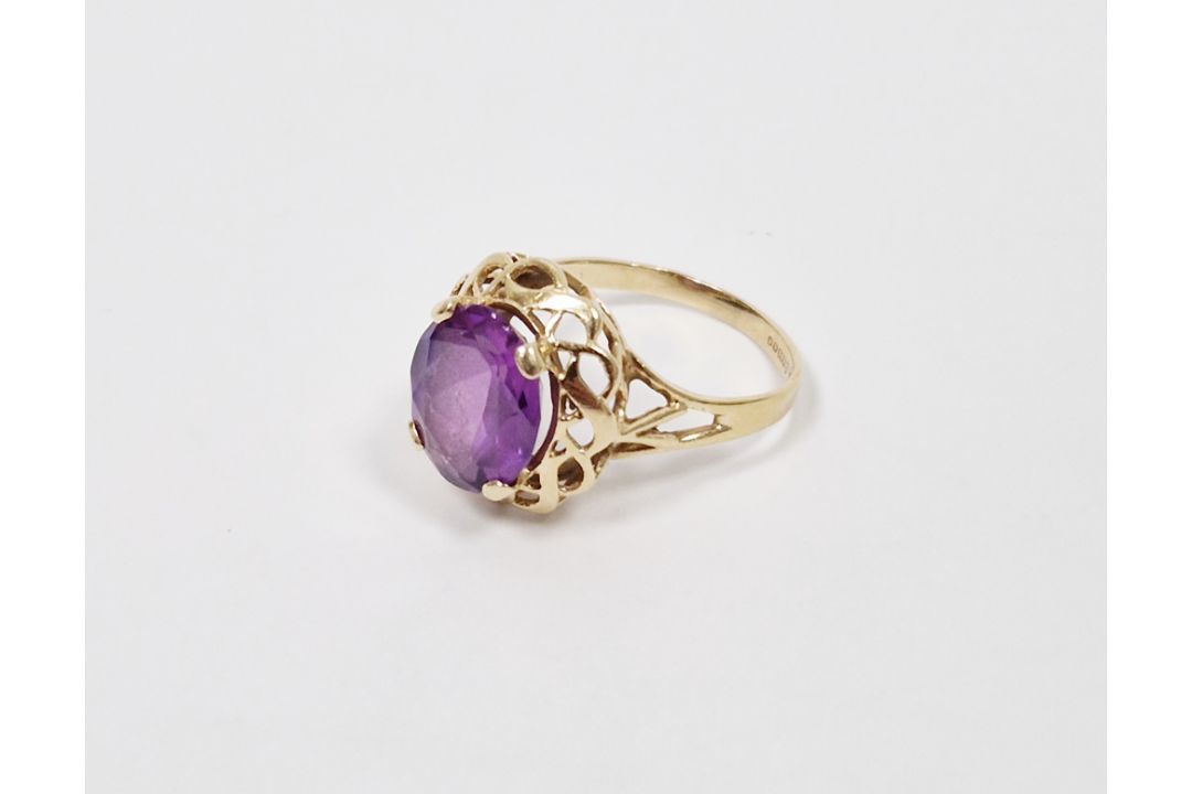 14K gold and purple stone ring, the oval stone in scroll bordered mount (size P) - Image 1 of 2