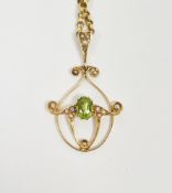 Edwardian 15ct gold, peridot and seedpearl pendant, scroll design with oval peridot, on gold-