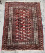 Bokhara-style wool rug with red field, having ten rows of two guls and multiple geometric border