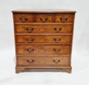 Yew wood chest of three short drawers over four graduating long drawers with metal swan neck handles