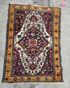 Eastern wool rug with midnight blue lozenge on an ivory ground and having ruby-coloured spandrels,