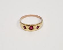 Late 19th / early 20th century yellow-metal ring set with a row of three round mixed cut rubies in