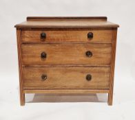Early 20th century oak chest of three long graduating drawers, with upstand and carved moulded