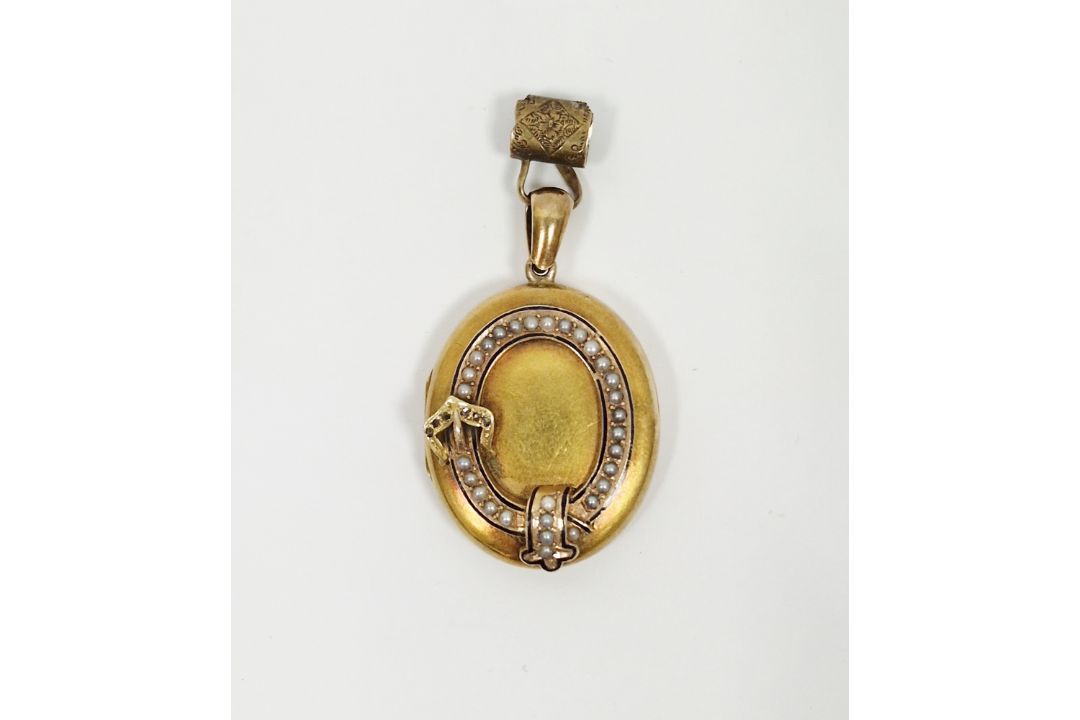 19th century yellow metal oval locket pendant, the front set with a raised band in the form of a