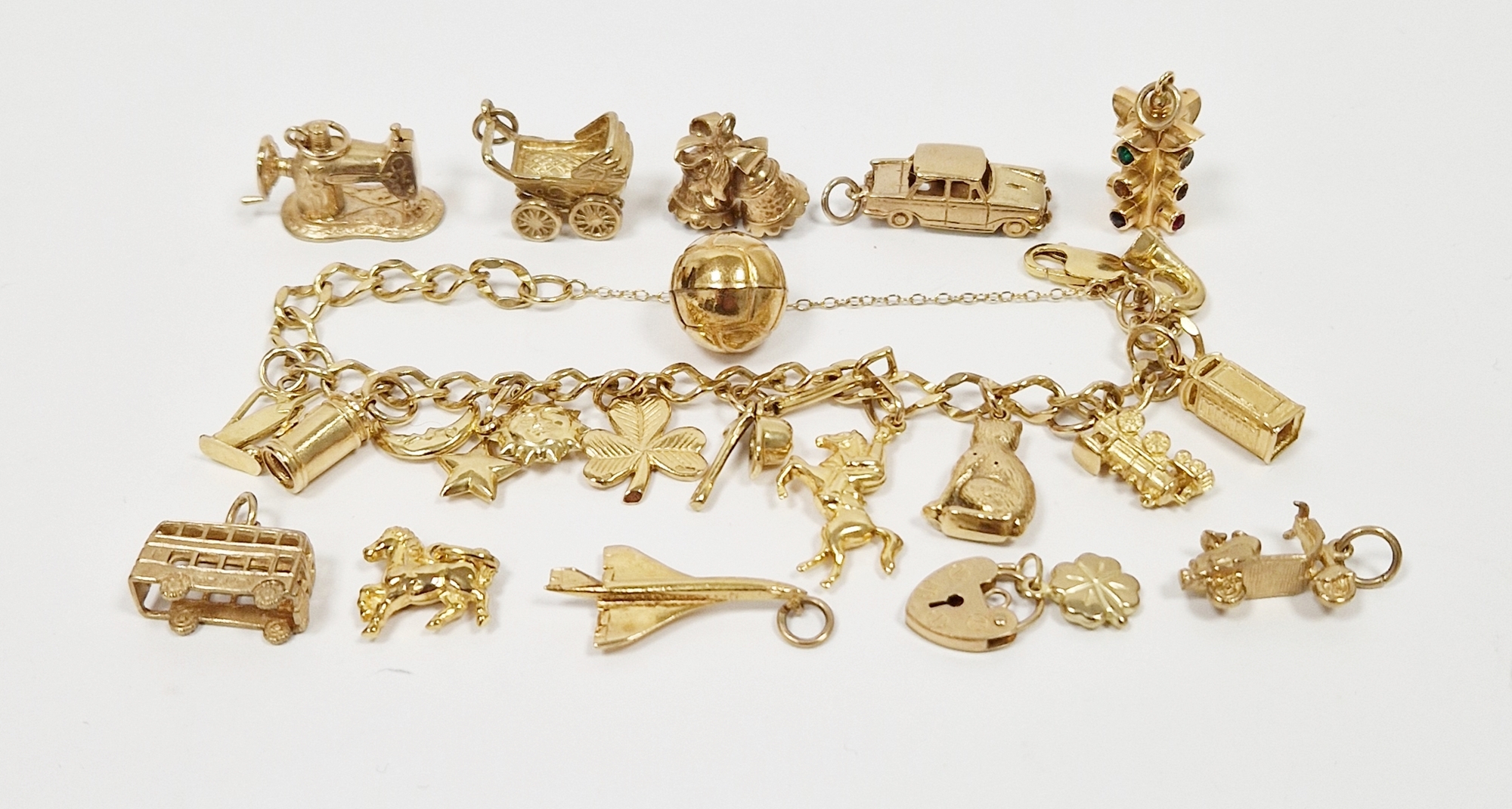 9ct gold oval link charm bracelet with quantity charms and sundry gold loose charms, 60g total