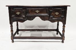Antique oak side table, the plain top above three moulded drawers and shaped frieze raised on turned