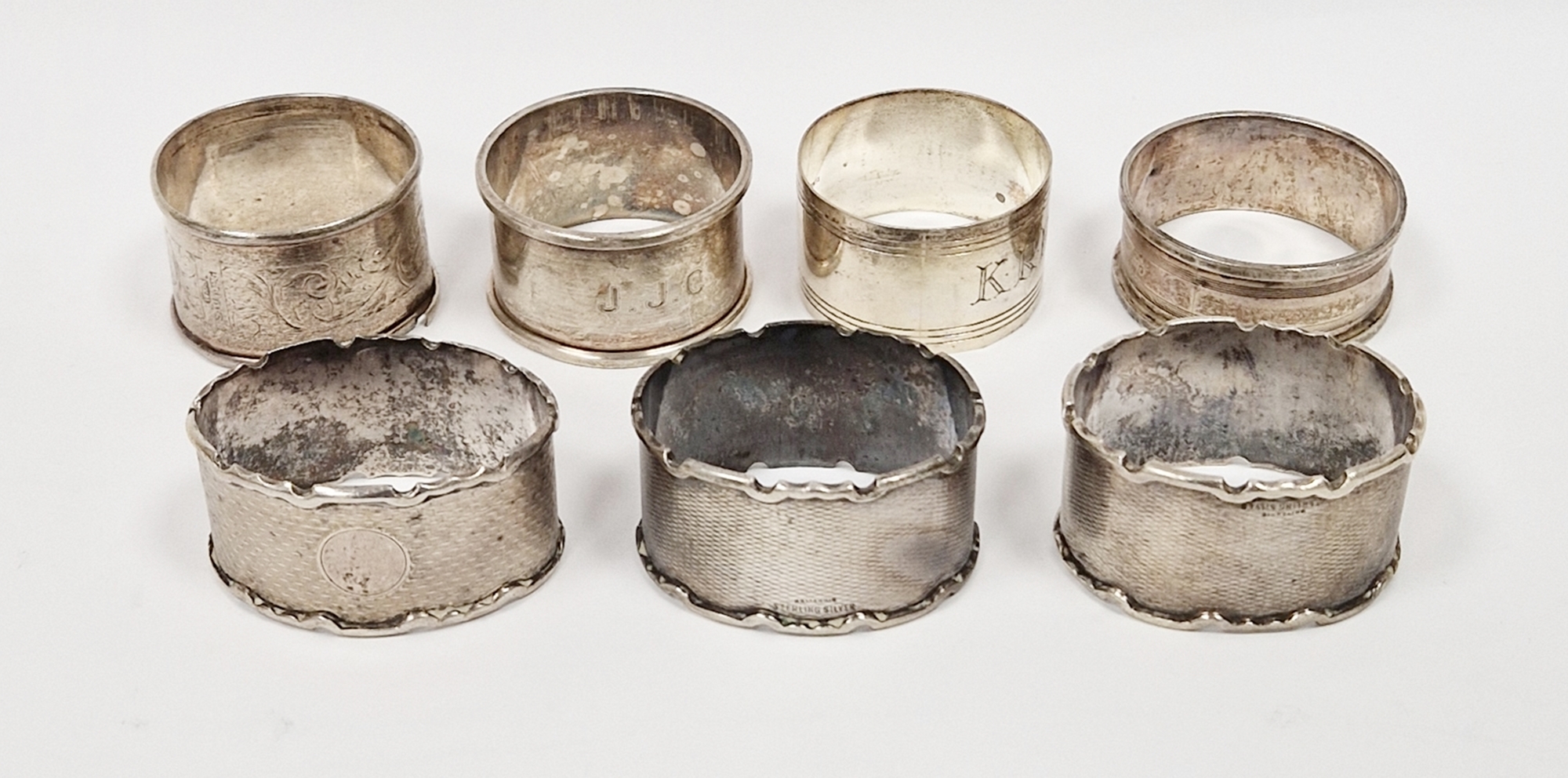 Set of three white metal oval napkin rings with engine turned decoration stamped Sterling silver