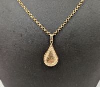 9ct yellow gold pear shaped locket with engraved scrolling decoration, 3.5cm to front held on a