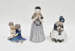 Three Danish porcelain figures, comprising: a Bing & Grondahl boy and girl in an embrace, a Royal