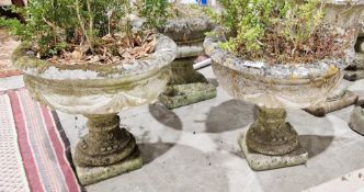 Pair of reconstituted stone shallow garden urns with swag design and fruiting vine design to base,