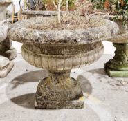 Reconstituted stone half gadrooned shallow garden urn on square section pedestal base, 51cm high x