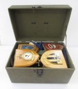 Box containing two brass shell cases, two pistol holsters, four military plaques, Sam Brown