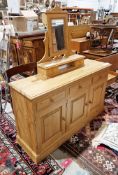 Modern pine dresser base with three short drawers and three cupboard doors, raised on a plinth base,