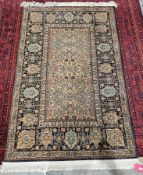 Turkish rug with beige, turquoise and rust centre, of floral design on black with borders with