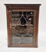 George III oak hanging corner cabinet, the single astragal glazed door opening to three shaped