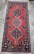 Hand knotted Iranian rug with three centre medallions, pink, blue, red, beige on red background,