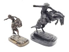After Frederick Remington, cast bronze model of the Bronco Buster raised on an oval black marble