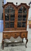 Early 20th century walnut bookcase cabinet in the Queen Anne manner, the double domed top with three