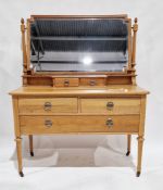 Early 20th century pale oak dressing table, the large rectangular mirror with bevelled edge and held