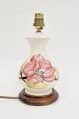 Moorcroft pottery 'Magnolia' pattern baluster lamp base on wooden stand, electrified, 18cm high (