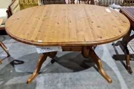 Modern pine oval dining table raised on twin substantial turned pedestals, each with two splayed