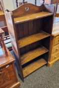 Early 20th century oak open bookcase, the shaped back with pierced heart motif, reeded sides and