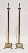 Pair of brass corinthian column standard lamps, raised on square stepped bases with four lion's