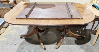 Mahogany D-end dining table in the Regency manner, the top with reeded edge and one additional leaf,