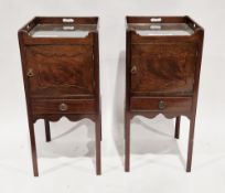 Two matching mahogany night stands in the George III manner, the tray tops with pierced handles over