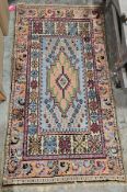Colourful wool rug the centre piece orange, green, burgundy and cream on turquoise background with