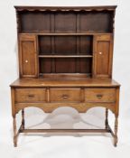 Early 20th century oak dresser in the 18th century manner, the upper section with shelf and two