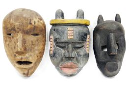 Three large tribal ethnic carved wooden face masks, including Nepal shaman ritual mask, Bamana style