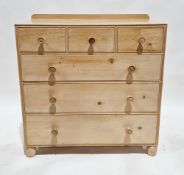 Bleached pine chest of three small drawers over three graduated long drawers with turned wooden