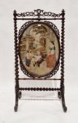 19th century rosewood firescreen, the frame with pierced carved panels and barleytwist supports
