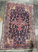Hand knotted Iranian rug, central red with reds, blues, orange, gold, cream and pink with blue