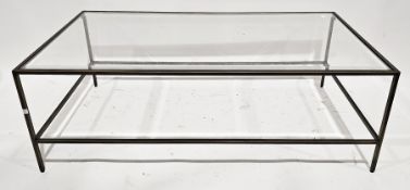 Contemporary coffee table with bevelled glass top held on a slender brass effect base, 120cm long